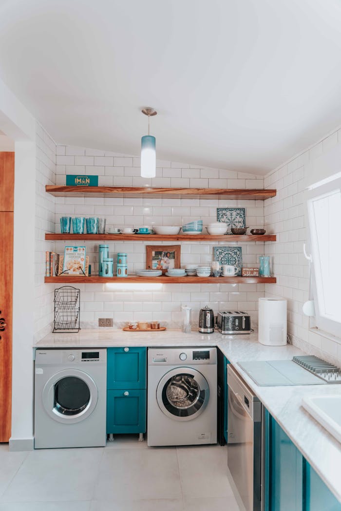 services-01 A bright modern kitchen featuring open shelving and integrated washing appliances.