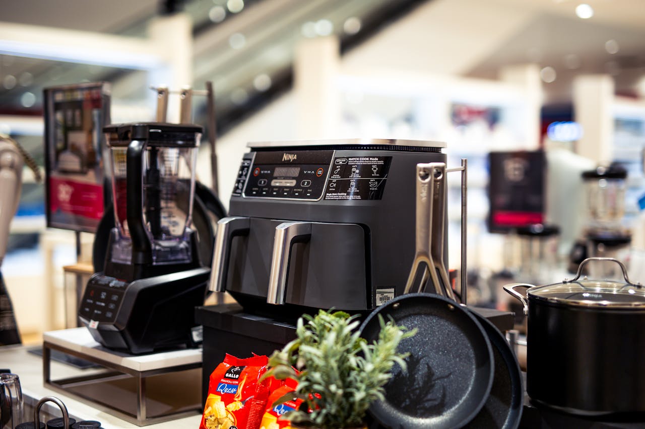 services-04 Showcase of modern kitchen appliances in a retail store, featuring blenders and cooking equipment.