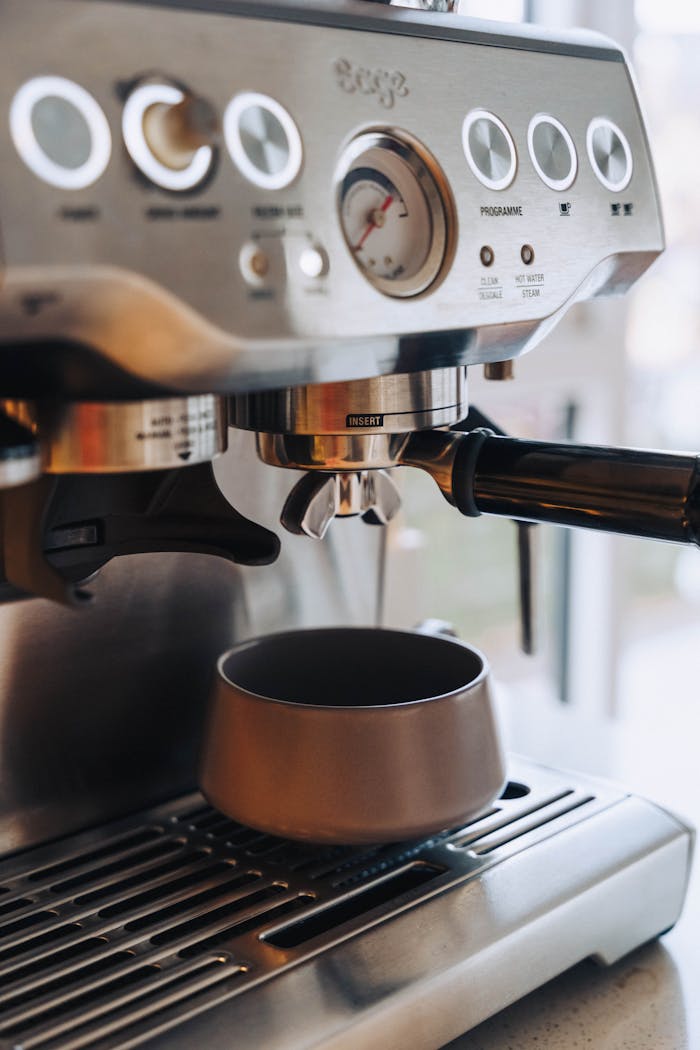 about-01 Close-up of a modern espresso machine making a fresh coffee shot indoors.