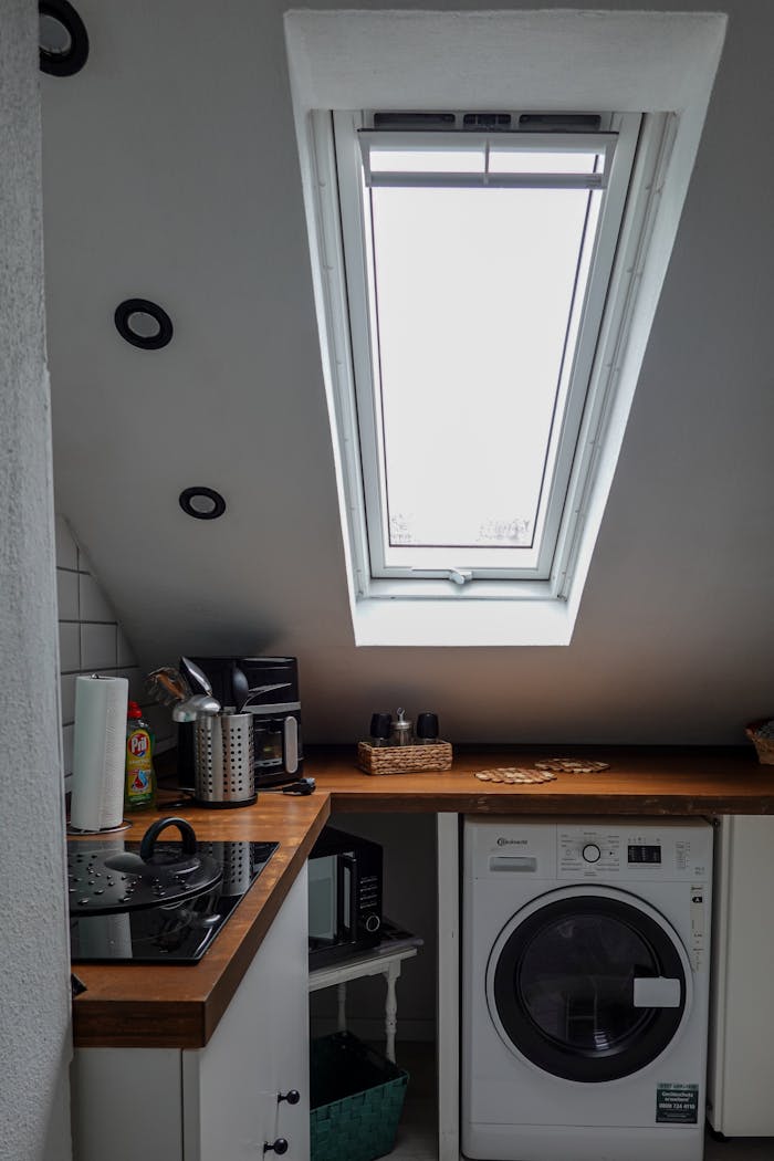 services-01 Cozy modern kitchen featuring a skylight window, washing machine, and countertop appliances.