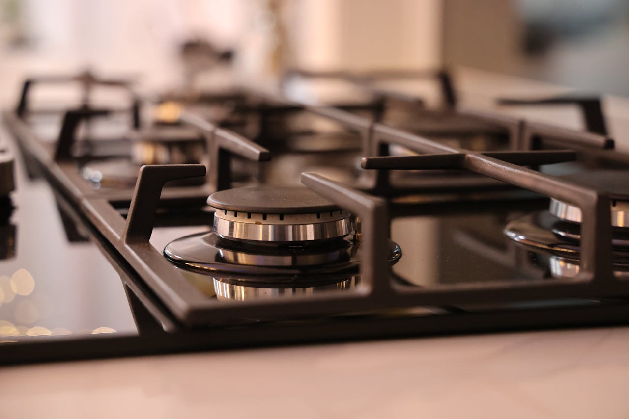 services-03 Close-up of a modern stainless steel gas stove top, ideal for contemporary kitchens and cooking environments.
